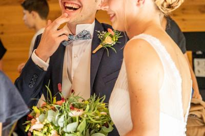 Grande maison en pierre entourée de verdure, avec une cour ensoleillée et des arbres en arrière-plan.