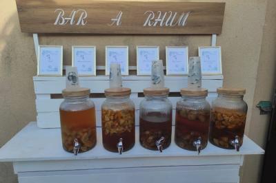 Grande maison en pierre entourée de verdure, avec une cour ensoleillée et des arbres en arrière-plan.