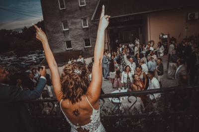 Grande maison en pierre entourée de verdure, avec une cour ensoleillée et des arbres en arrière-plan.