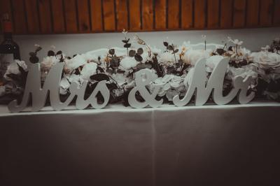 Grande maison en pierre entourée de verdure, avec une cour ensoleillée et des arbres en arrière-plan.