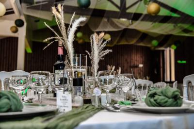 Grande maison en pierre entourée de verdure, avec une cour ensoleillée et des arbres en arrière-plan.