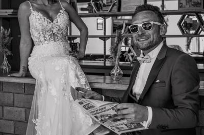 Grande maison en pierre entourée de verdure, avec une cour ensoleillée et des arbres en arrière-plan.