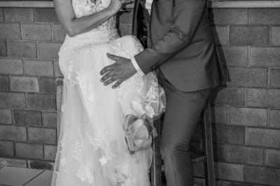 Grande maison en pierre entourée de verdure, avec une cour ensoleillée et des arbres en arrière-plan.