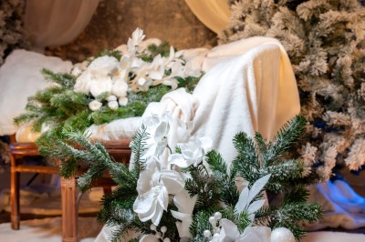 Un couple en tenue de mariage pose dans un champ au coucher du soleil, la mariée tenant un bouquet de fleurs blanches.