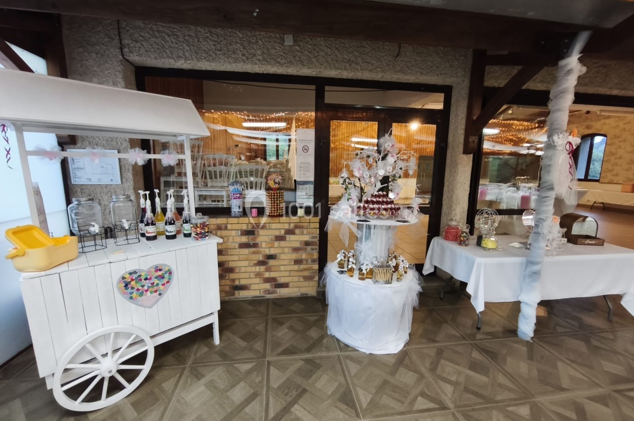 Stand de confiseries et pâtisseries décoré pour un événement, avec chariot blanc et présentoirs garnis.