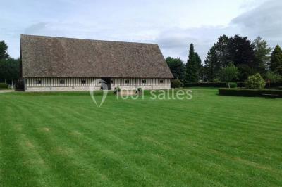 Table ronde élégamment dressée avec nappes blanches, verres, couverts, pains et décoration florale dans une salle de…