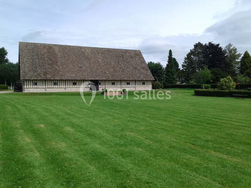 Bâtiment traditionnel à colombages entouré d'une pelouse bien entretenue et de quelques arbres en arrière-plan.