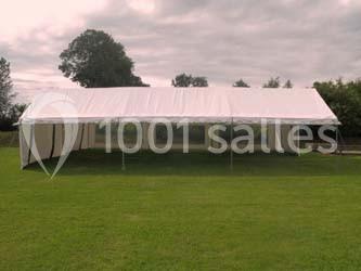 Table ronde élégamment dressée avec nappes blanches, verres, couverts, pains et décoration florale dans une salle de…