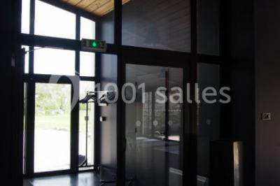 Deux lits simples avec linge à motifs floraux dans une chambre aux murs roses, éclairée par des lampes de chevet.