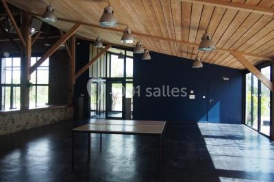 Deux lits simples avec linge à motifs floraux dans une chambre aux murs roses, éclairée par des lampes de chevet.