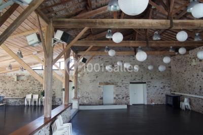 Deux lits simples avec linge à motifs floraux dans une chambre aux murs roses, éclairée par des lampes de chevet.