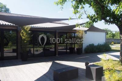 Deux lits simples avec linge à motifs floraux dans une chambre aux murs roses, éclairée par des lampes de chevet.