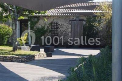 Deux lits simples avec linge à motifs floraux dans une chambre aux murs roses, éclairée par des lampes de chevet.