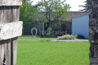 Deux lits simples avec linge à motifs floraux dans une chambre aux murs roses, éclairée par des lampes de chevet.