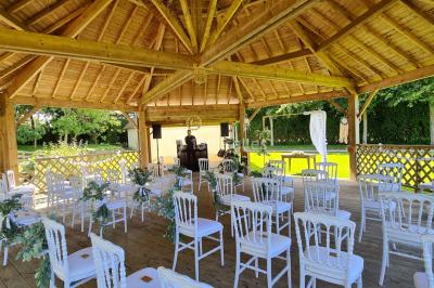 Pressoir ancien en bois dans une pièce avec murs en pierre, plafond à poutres apparentes et sol en parquet.