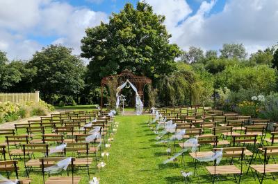 Pressoir ancien en bois dans une pièce avec murs en pierre, plafond à poutres apparentes et sol en parquet.