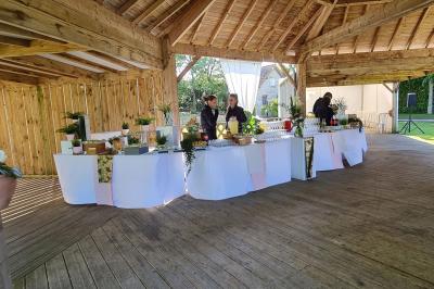 Pressoir ancien en bois dans une pièce avec murs en pierre, plafond à poutres apparentes et sol en parquet.