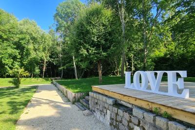 Pressoir ancien en bois dans une pièce avec murs en pierre, plafond à poutres apparentes et sol en parquet.