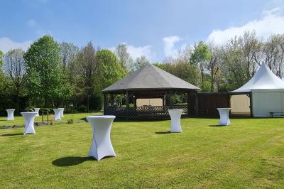 Pressoir ancien en bois dans une pièce avec murs en pierre, plafond à poutres apparentes et sol en parquet.