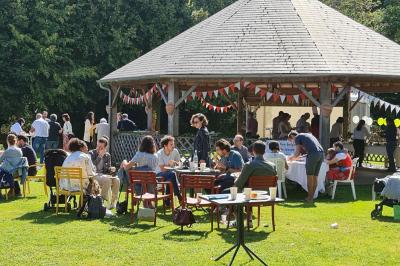 Pressoir ancien en bois dans une pièce avec murs en pierre, plafond à poutres apparentes et sol en parquet.