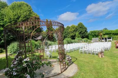 Pressoir ancien en bois dans une pièce avec murs en pierre, plafond à poutres apparentes et sol en parquet.