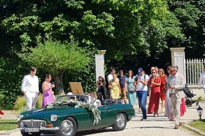 Pressoir ancien en bois dans une pièce avec murs en pierre, plafond à poutres apparentes et sol en parquet.