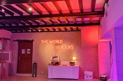 Pressoir ancien en bois dans une pièce avec murs en pierre, plafond à poutres apparentes et sol en parquet.