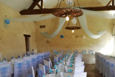 Grande maison blanche entourée d'arbres et d'une pelouse verte sous un ciel légèrement nuageux.