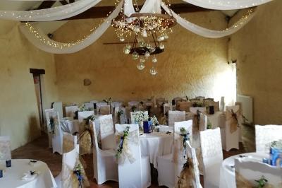 Grande maison blanche entourée d'arbres et d'une pelouse verte sous un ciel légèrement nuageux.