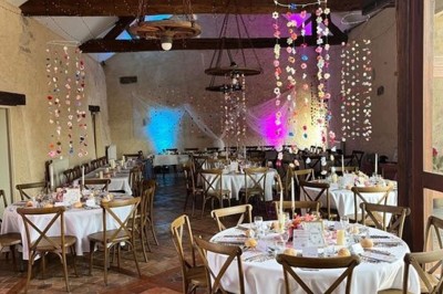 Chambre avec poutres apparentes, lit simple, armoire ancienne, bureau, chaise et fenêtre ouverte sur l'extérieur.
