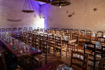 Chambre avec poutres apparentes, lit simple, armoire ancienne, bureau, chaise et fenêtre ouverte sur l'extérieur.