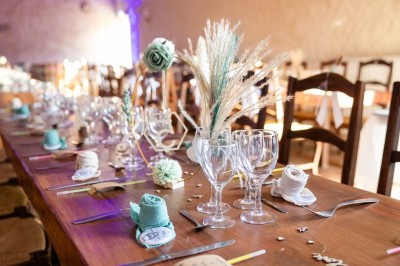 Chambre avec poutres apparentes, lit simple, armoire ancienne, bureau, chaise et fenêtre ouverte sur l'extérieur.