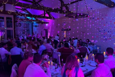 Chambre avec poutres apparentes, lit simple, armoire ancienne, bureau, chaise et fenêtre ouverte sur l'extérieur.