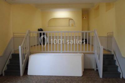 Champ verdoyant bordé d'arbres en automne, avec un grand bâtiment blanc visible à l'arrière-plan.