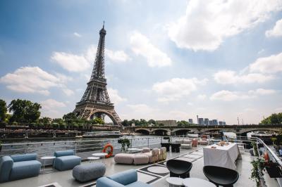 Vue de la tour Eiffel depuis les quais de la Seine, avec un bateau nommé ’Boreas’ au premier plan.