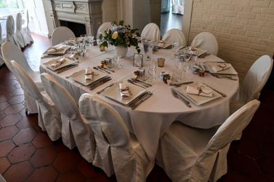 Des lanternes lumineuses flottent dans la nuit près d'une grande maison éclairée en bleu, entourée de personnes.
