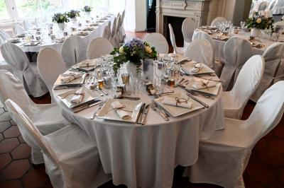 Des lanternes lumineuses flottent dans la nuit près d'une grande maison éclairée en bleu, entourée de personnes.