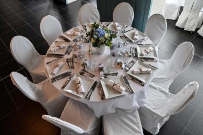 Des lanternes lumineuses flottent dans la nuit près d'une grande maison éclairée en bleu, entourée de personnes.