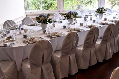 Des lanternes lumineuses flottent dans la nuit près d'une grande maison éclairée en bleu, entourée de personnes.
