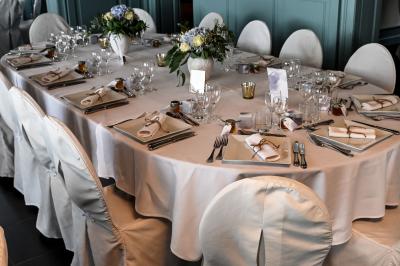 Des lanternes lumineuses flottent dans la nuit près d'une grande maison éclairée en bleu, entourée de personnes.