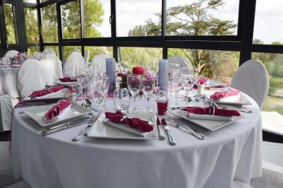 Des lanternes lumineuses flottent dans la nuit près d'une grande maison éclairée en bleu, entourée de personnes.