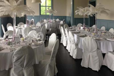 Des lanternes lumineuses flottent dans la nuit près d'une grande maison éclairée en bleu, entourée de personnes.