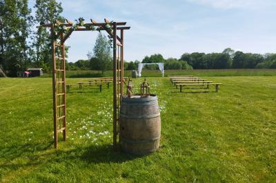 Salle décorée avec des guirlandes roses et blanches, tables dressées pour un buffet sous une charpente en bois.