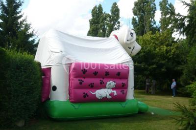 Chambre mansardée avec poutres apparentes, trois lits, une table et des chaises, éclairée par une fenêtre de toit.