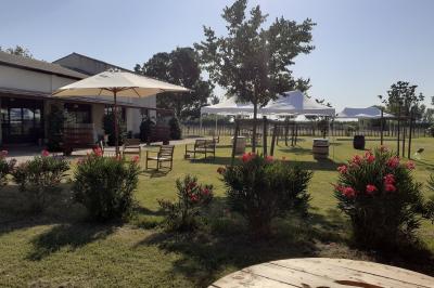 Salle de réception décorée avec des nappes blanches et des rubans rouges, tables ornées de centres de table fleuris.