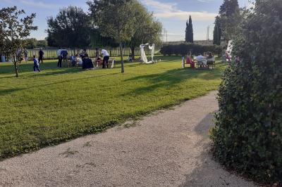 Salle de réception décorée avec des nappes blanches et des rubans rouges, tables ornées de centres de table fleuris.