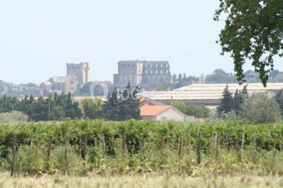 Salle de réception décorée avec des nappes blanches et des rubans rouges, tables ornées de centres de table fleuris.