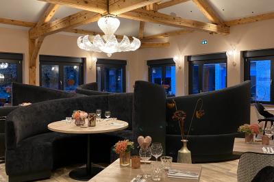 Buffet de petit-déjeuner avec viennoiseries, fruits, confitures, charcuterie et machine à café dans un décor en bois clair.