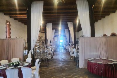 Église en pierre avec une tour, entourée de végétation et éclairée par une lumière naturelle sous un ciel bleu.