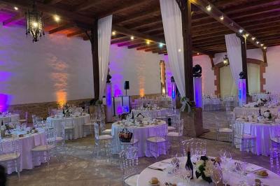 Église en pierre avec une tour, entourée de végétation et éclairée par une lumière naturelle sous un ciel bleu.